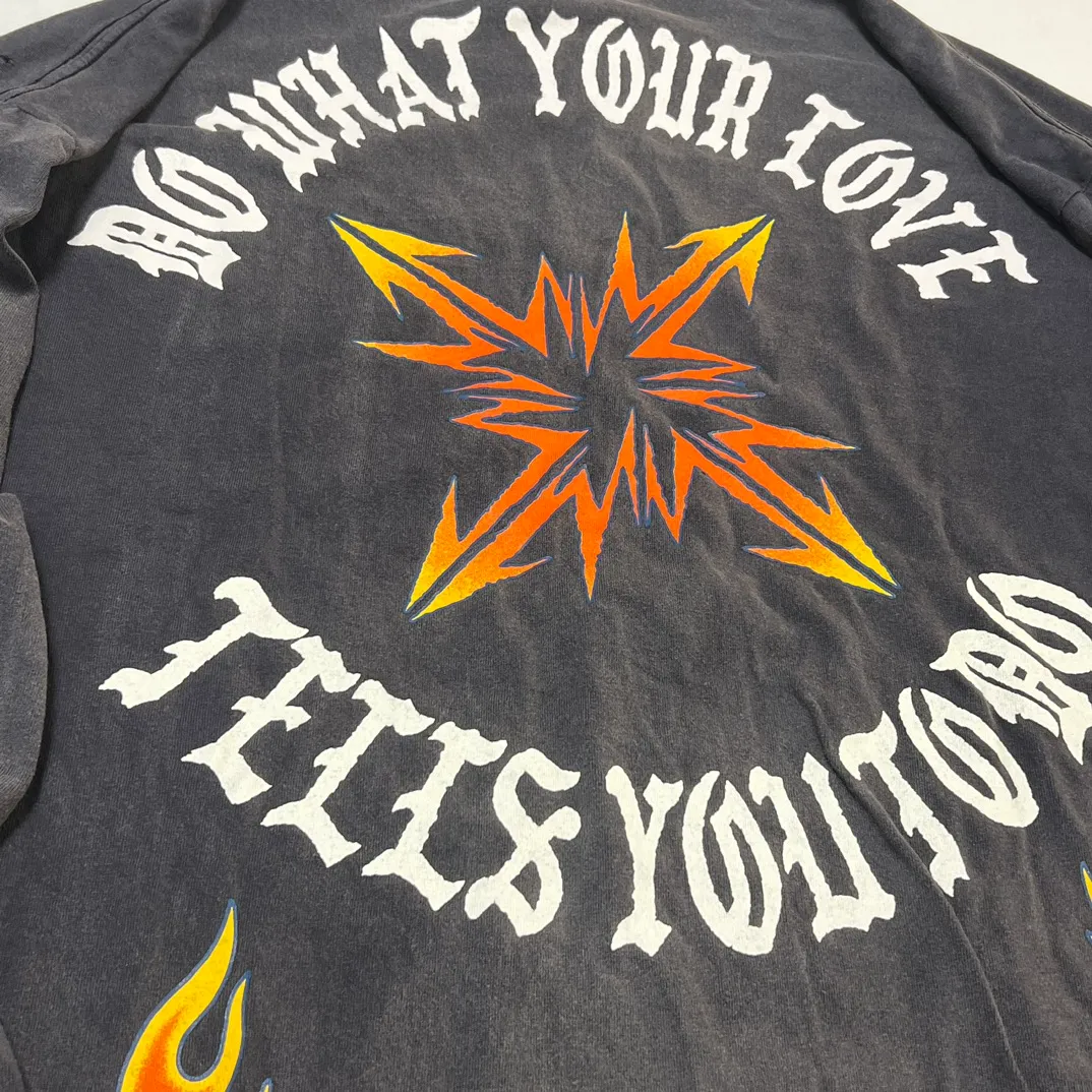 SAINT Mxxxxxx M/AFTER LS_TEE/BLACK Flame arrow Letter M retro distressed long tee Washed black S-XL Tubular fabric Assute ready-made garments dyed The whole piece is sprayed with horse-hair spray and then sprayed again to fade the color. The collar and cuffs are frayed. Many places are frayed. Extra large printing position. Very difficult to print. Complete accessories. With little angel anti-counterfeiting label.